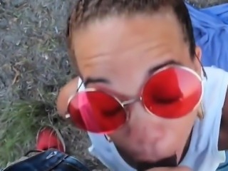 Cute ebony is outside wearing shades while sucking his blac
